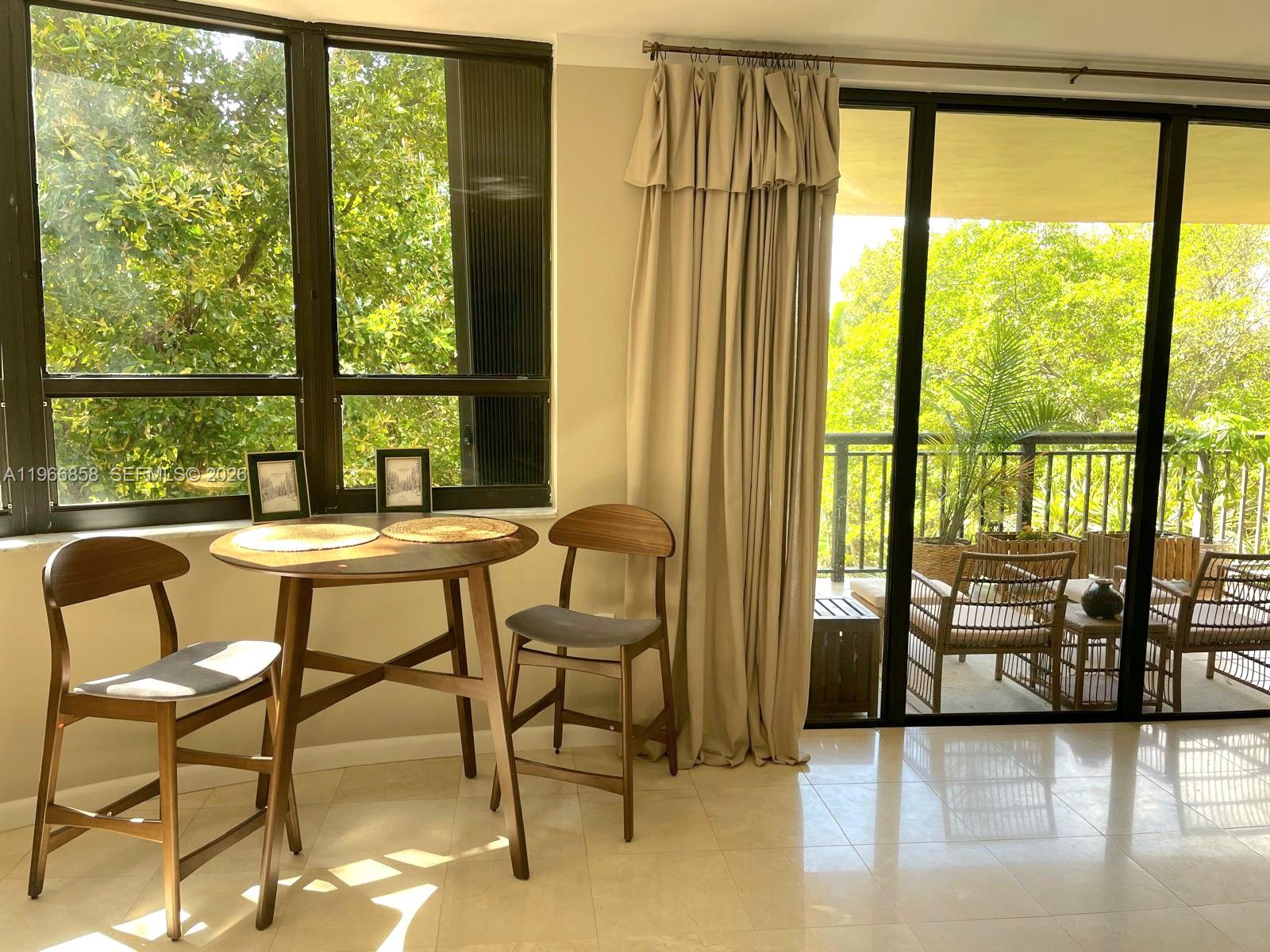 10175 Collins Avenue, Unit 208 Bal Harbour, FL 33154 - Photo 7 of 16 a view of a room with a table and chairs