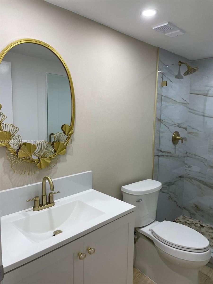 10175 Collins Avenue, Unit 208 Bal Harbour, FL 33154 - Photo 8 of 16 a bathroom with a sink mirror vanity and toilet