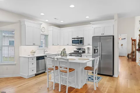 a kitchen with stainless steel appliances kitchen island granite countertop a refrigerator and a stove top oven