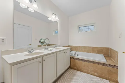a bathroom with a tub a sink and mirror
