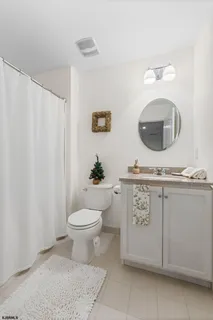 a bathroom with a granite countertop toilet sink and mirror