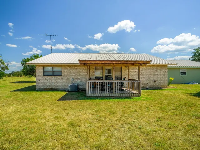 a view of a house with a yard and sitting area