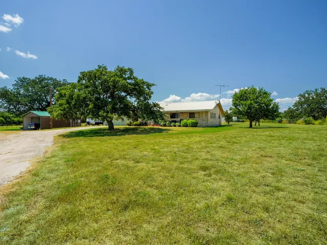 a view of a green field with trees in the background