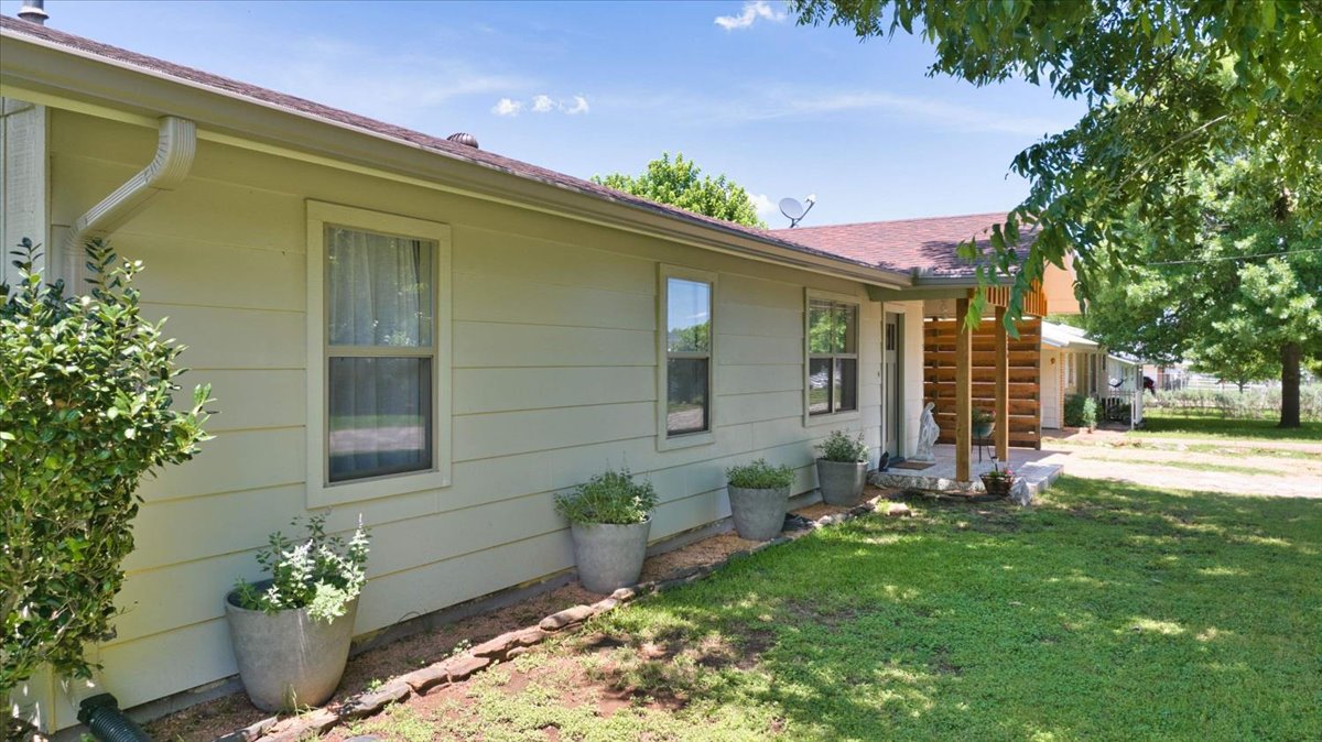 1236 Martin Street Mason, TX 76856 - Photo 28 of 40 A classic facade with a charming porch entrance, nestled among verdant trees and a manicured lawn.