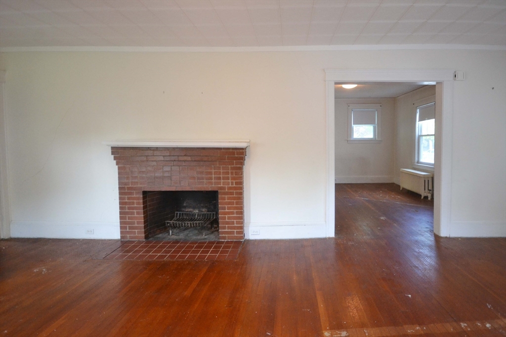 122 Morningside Road Worcester, MA 01602 - Photo 19 of 35 a view of an empty room with wooden floor fireplace and a window