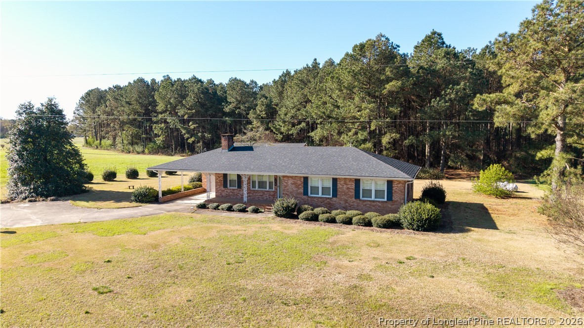 5424 Bonnetsville Road Clinton, NC 28328 - Photo 21 of 29 a front view of a house with a yard covered with snow and trees