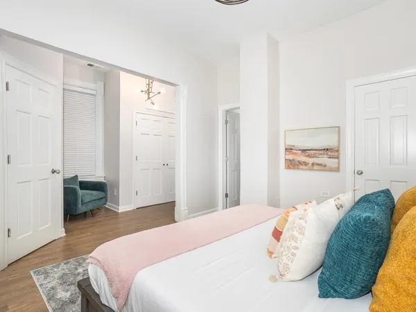 a bedroom with a large bed and a chandelier