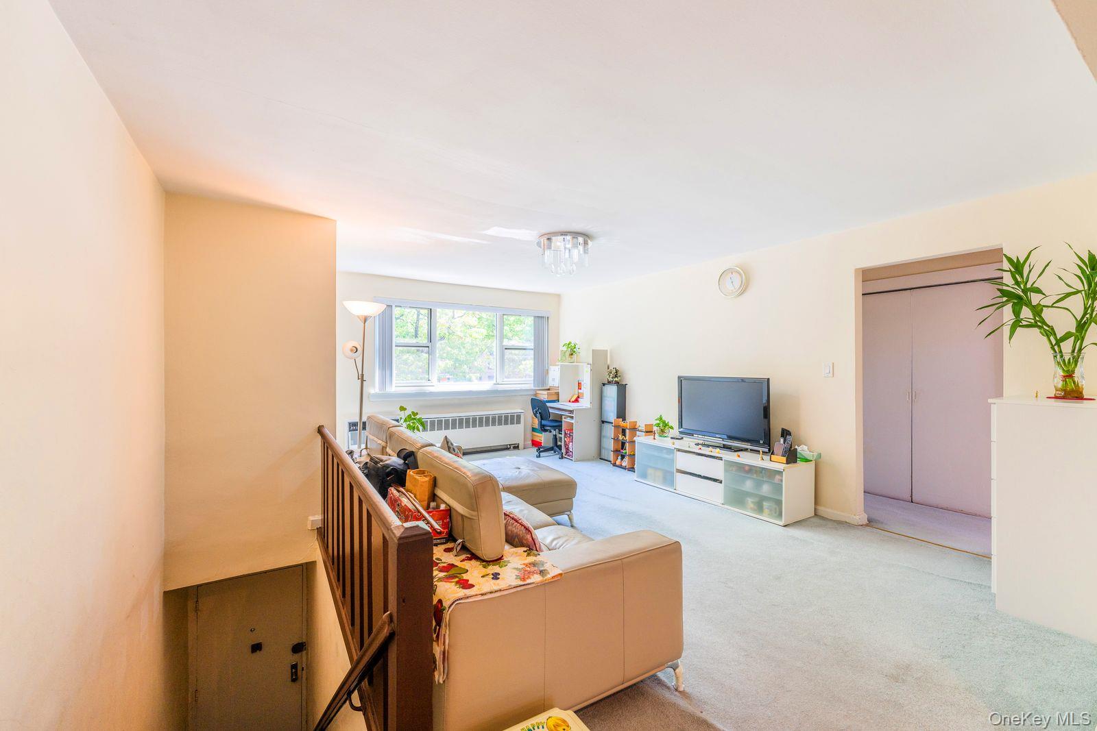69-28 Kissena Boulevard, Unit 130B Queens, NY 11367 - Photo 17 of 20 a living room with furniture and a flat screen tv