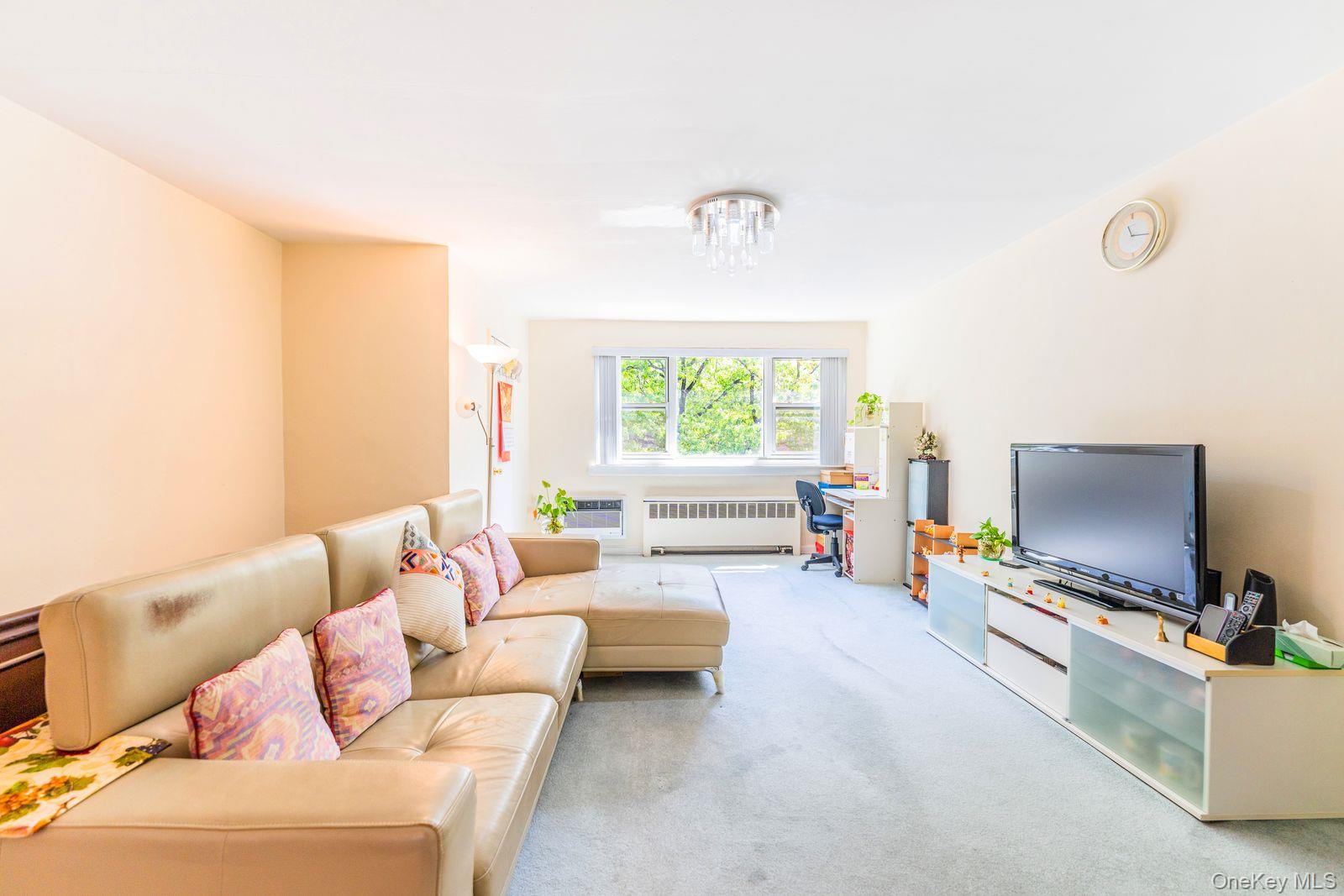 69-28 Kissena Boulevard, Unit 130B Queens, NY 11367 - Photo 3 of 20 a living room with furniture and a flat screen tv