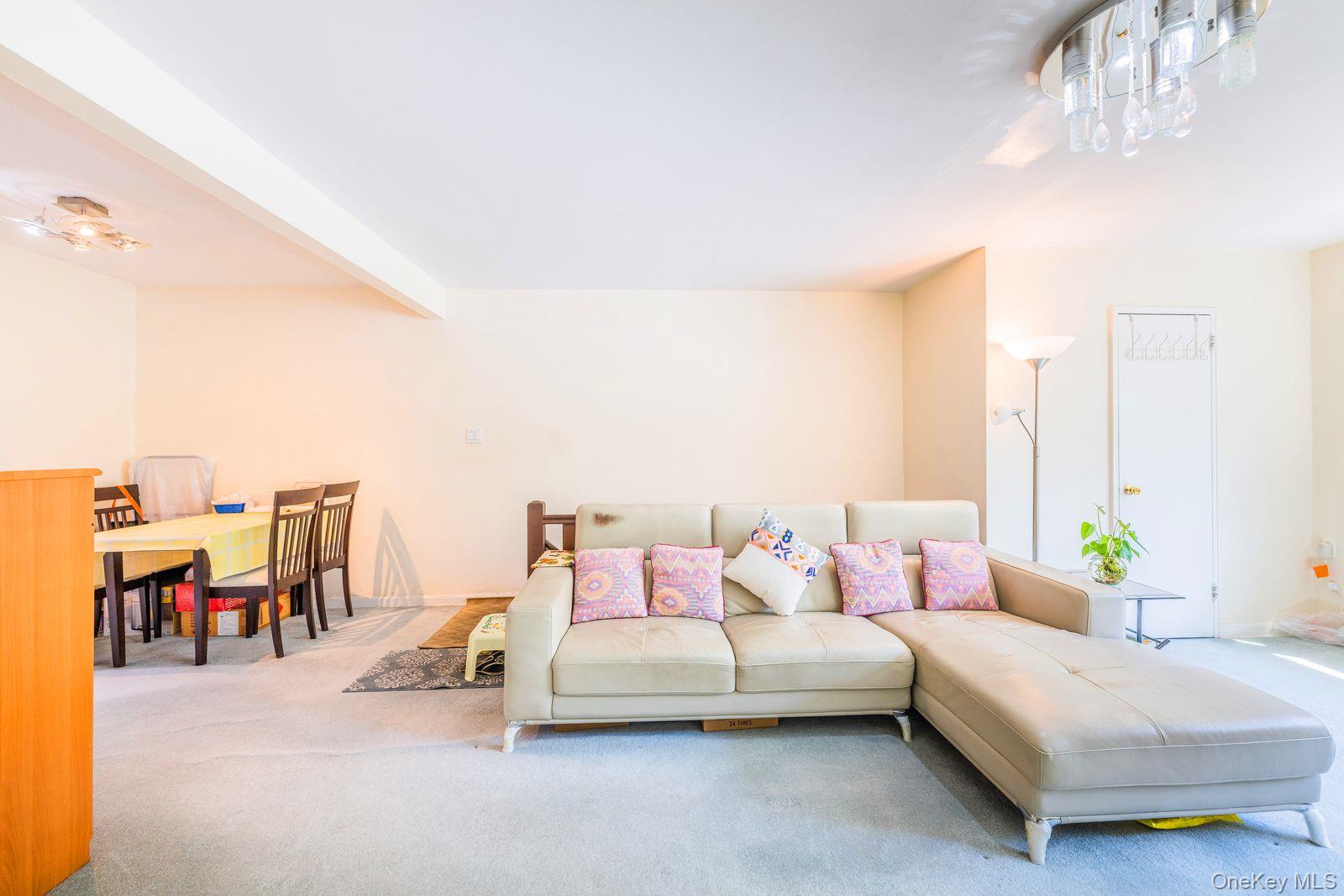 69-28 Kissena Boulevard, Unit 130B Queens, NY 11367 - Photo 4 of 20 a bedroom with furniture and a chandelier