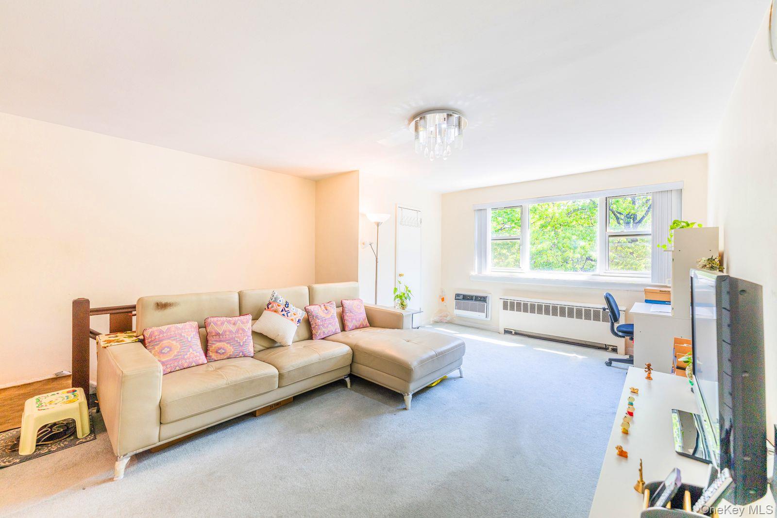 69-28 Kissena Boulevard, Unit 130B Queens, NY 11367 - Photo 6 of 20 a living room with furniture and a large window