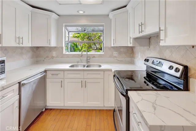 a kitchen with stainless steel appliances granite countertop a sink stove and cabinets