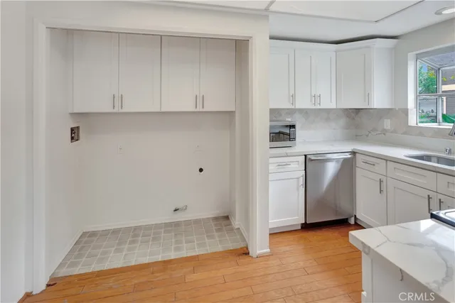 a kitchen with white cabinets and sink