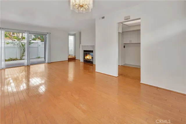 a view of empty room with wooden floor and fireplace