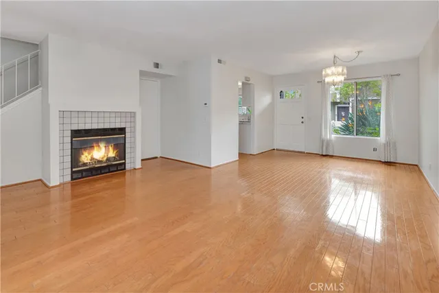 an empty room with windows and fireplace