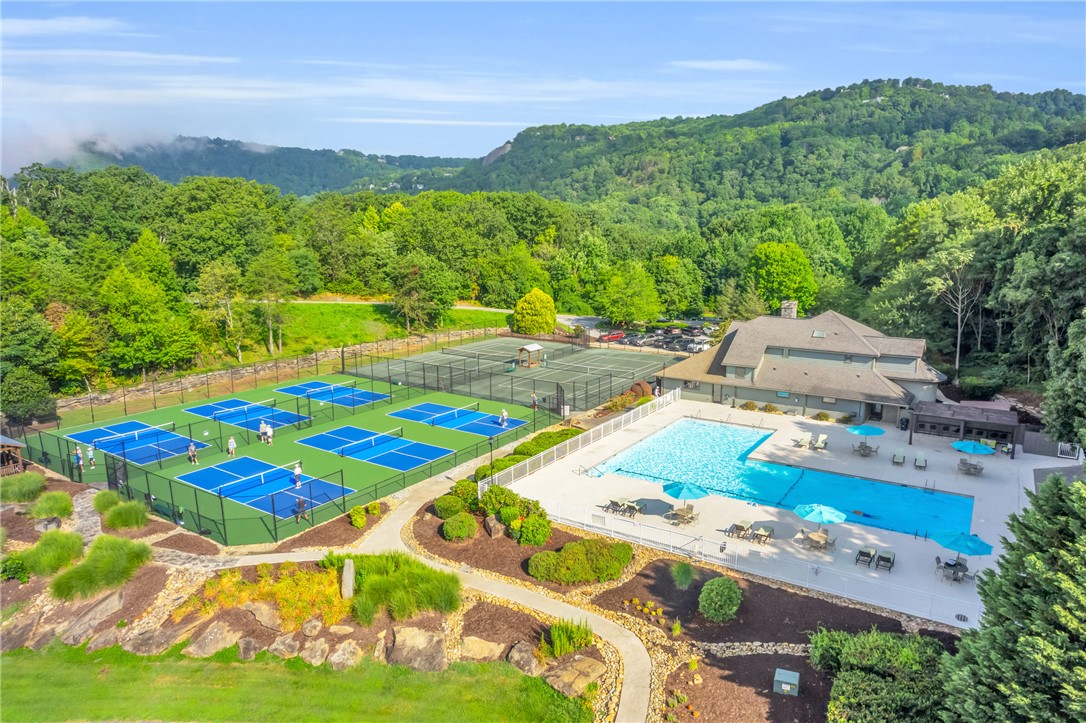 116 Witch Hazel Trail Landrum, SC 29356 - Photo 20 of 26 This recreational haven features an inviting pool, multiple pickleball courts, and tennis courts, set amidst a vibrant green landscape.