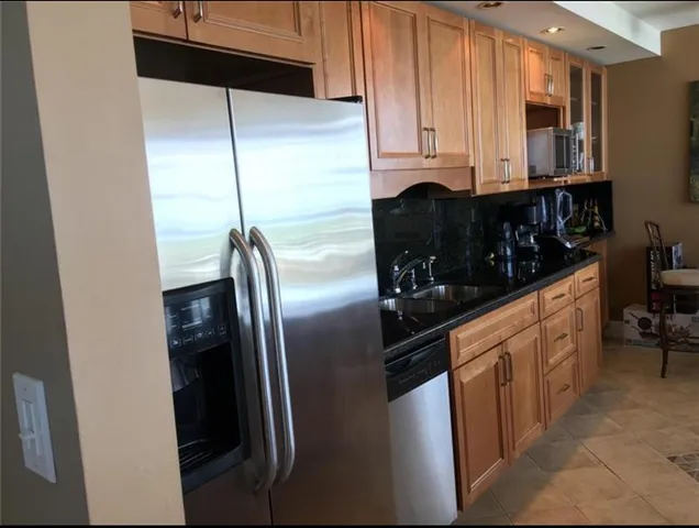 a kitchen with stainless steel appliances a refrigerator sink and cabinets