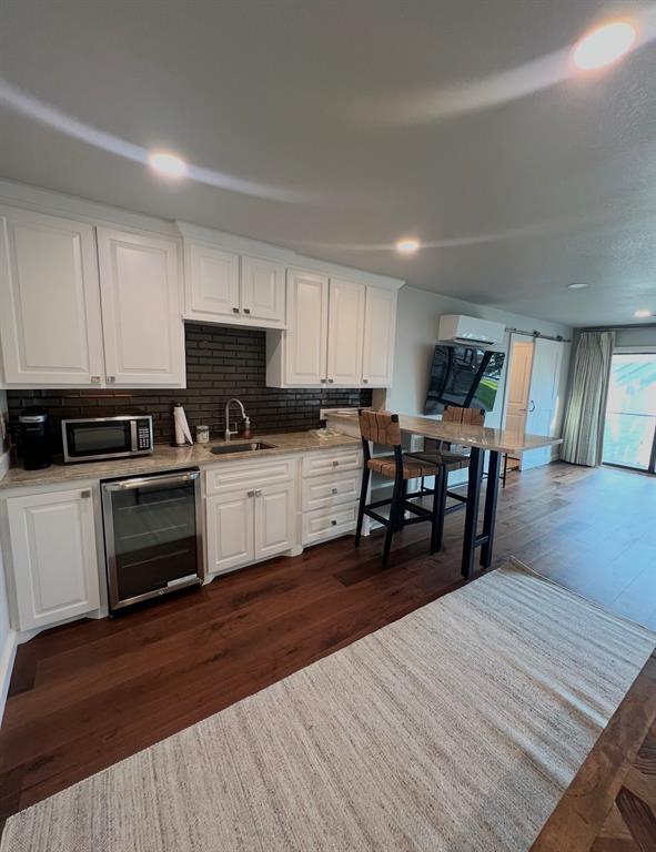 260 Cypress Marina Road Scroggins, TX 75480 - Photo 33 of 40 a kitchen with granite countertop wooden floors a stove and a microwave