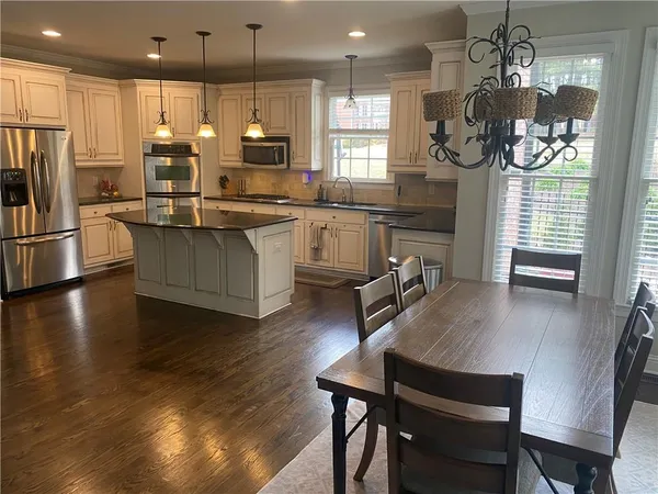 a kitchen with counter space dining table and wooden floor