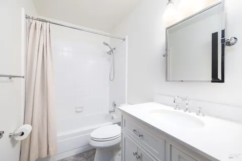 a bathroom with a granite countertop sink toilet and shower