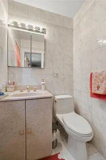 a bathroom with a granite countertop toilet sink and mirror