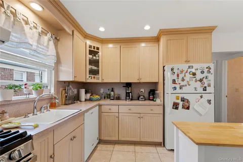 a kitchen with a sink a refrigerator and cabinets