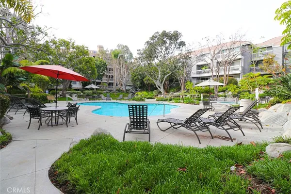 a view of a garden with a table and chairs under an umbrella