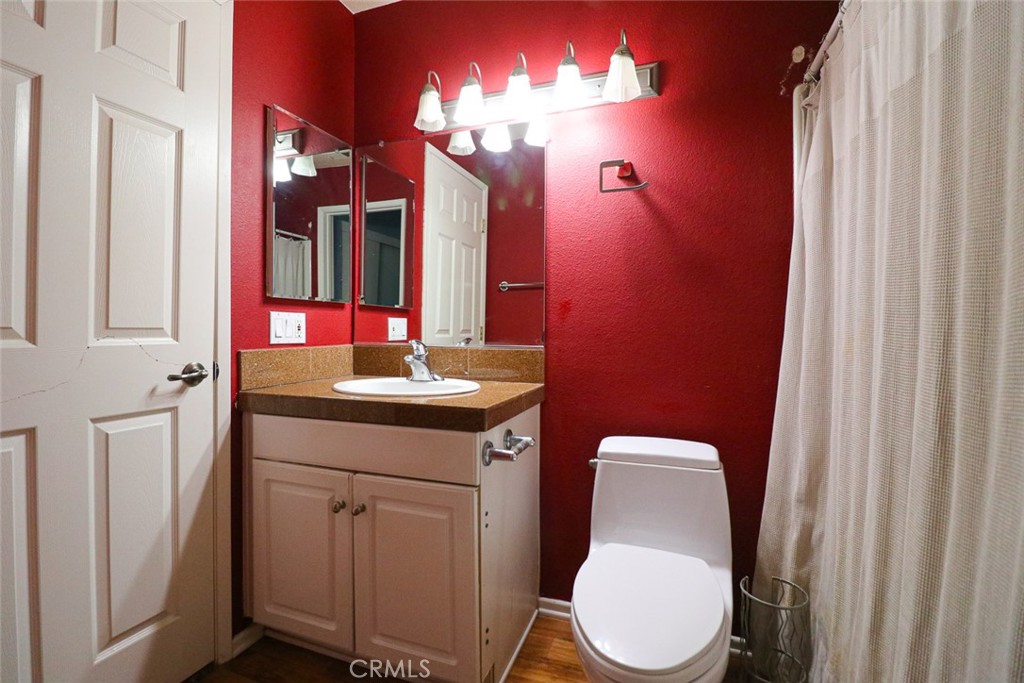 20331 Bluffside Circle, Unit 417 Huntington Beach, CA 92646 - Photo 5 of 32 a bathroom with a toilet sink and mirror