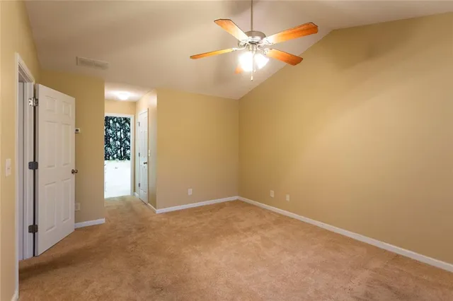 an empty room with a fan & a table