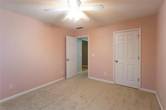 an empty room with closet and a chandelier fan