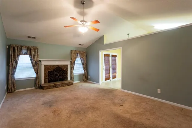 wooden floor fireplace and window in an empty room
