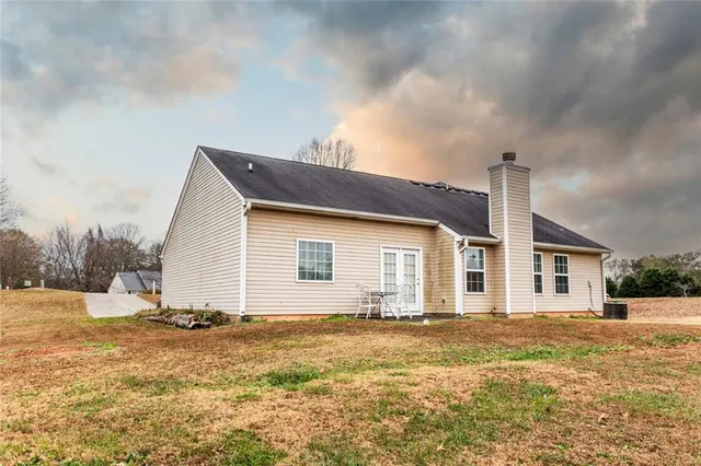a front view of house with yard and trees around