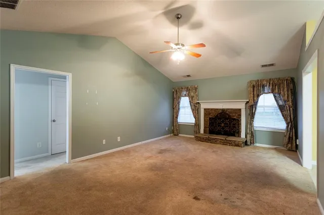 an empty room with fireplace and fan