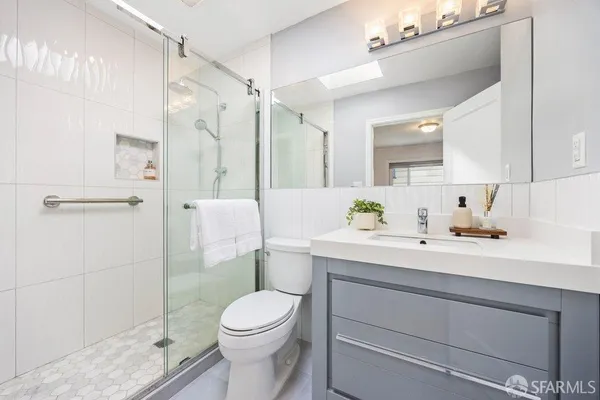 a bathroom with a sink a toilet and shower