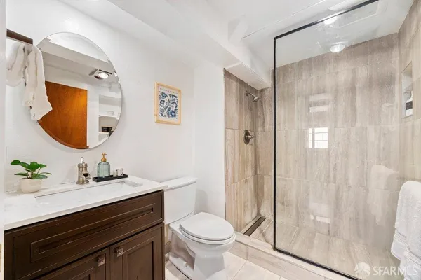 a bathroom with a sink vanity mirror and toilet