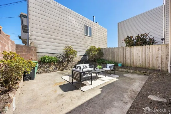 a view of backyard with outdoor seating a patio and plants