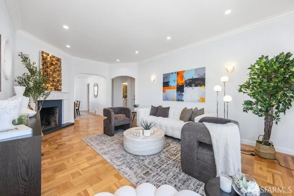 a living room with fireplace furniture and a potted plant