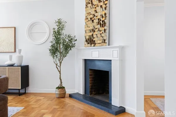 a living room with a fireplace and a potted plant