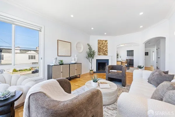 a living room with furniture fireplace and a large window