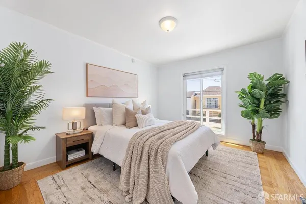 a bedroom with a large bed and a potted plant