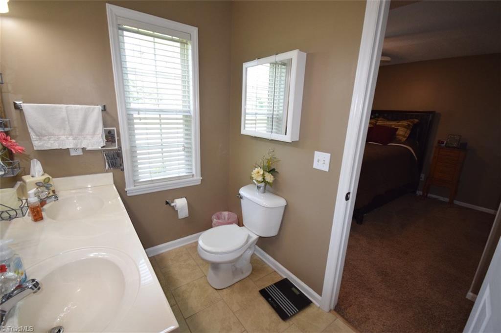 4596 Reid Road Elon, NC 27244 - Photo 13 of 21 master bath, dual sinks, tile floor, full size shower, with glass doors, (no tub)