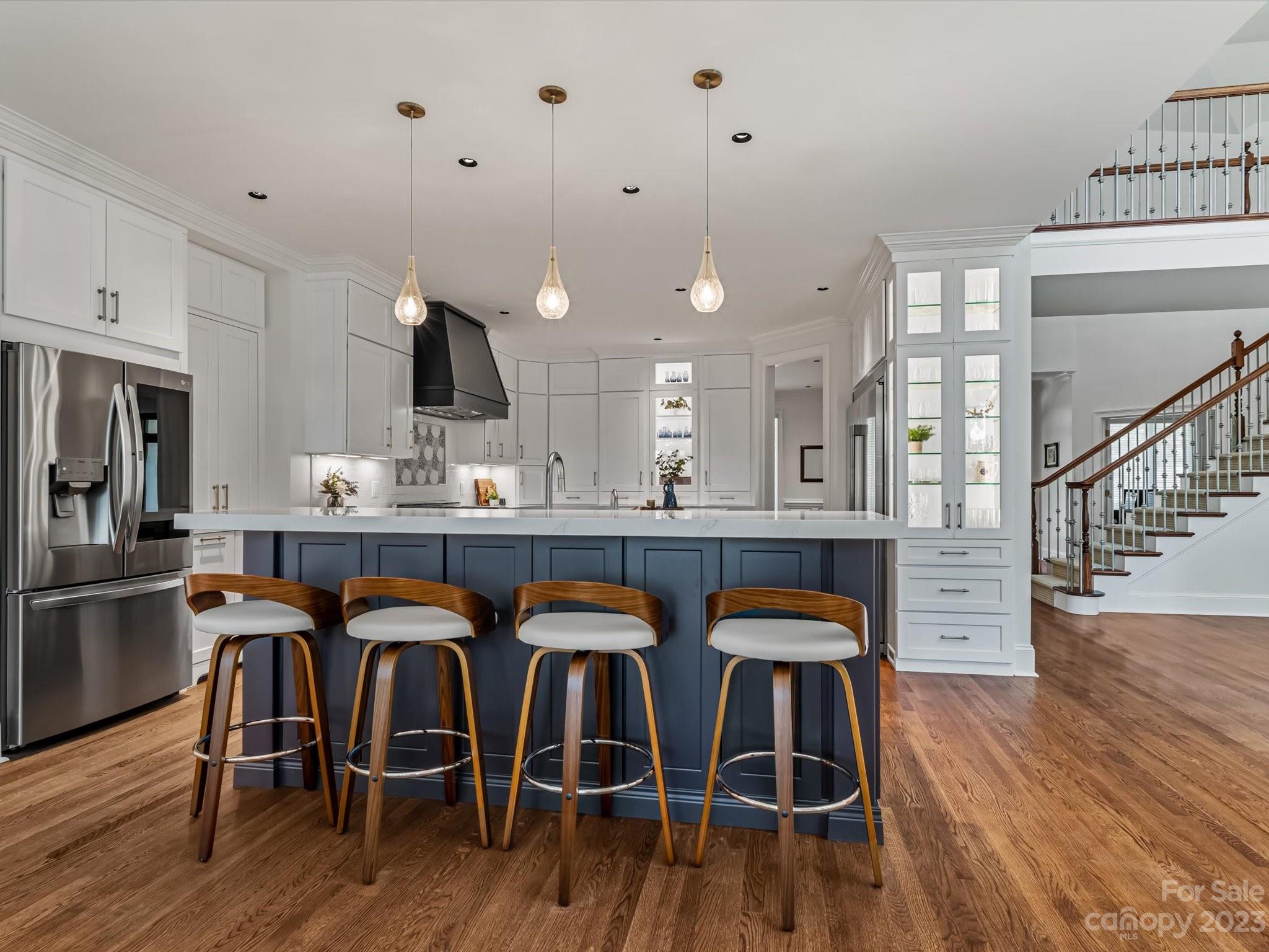 18916 Riverwind Lane Davidson, NC 28036 - Photo 6 of 25 a kitchen with stainless steel appliances a dining table chairs and wooden floor