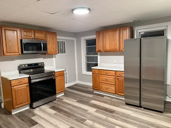 a kitchen with stainless steel appliances kitchen island granite countertop a refrigerator stove and sink