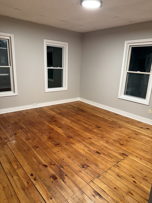 218 Vernon Street, Unit 3 Worcester, MA 01607 - Photo 5 of 8 a view of an empty room with wooden floor and a window