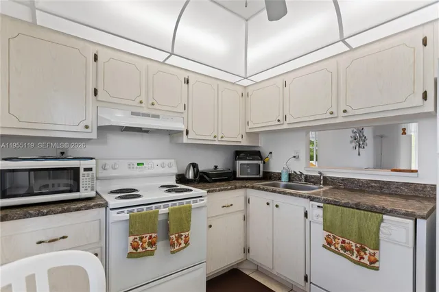 a kitchen with stainless steel appliances granite countertop a sink a stove and cabinets