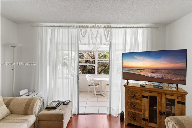 a living room with furniture a flat screen tv and a large window