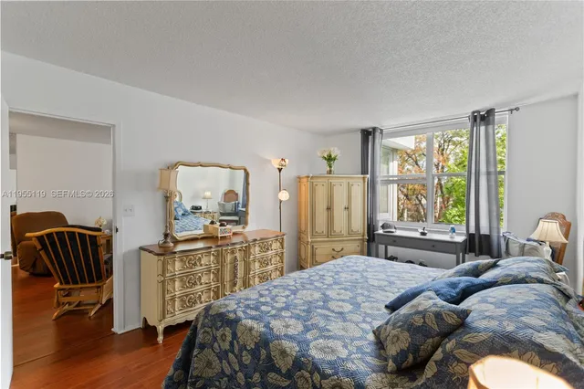 a bedroom with a bed and a dresser next to a window