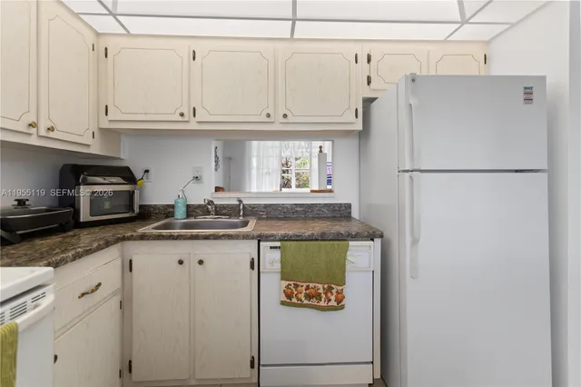 a kitchen with stainless steel appliances granite countertop a refrigerator a stove and a sink
