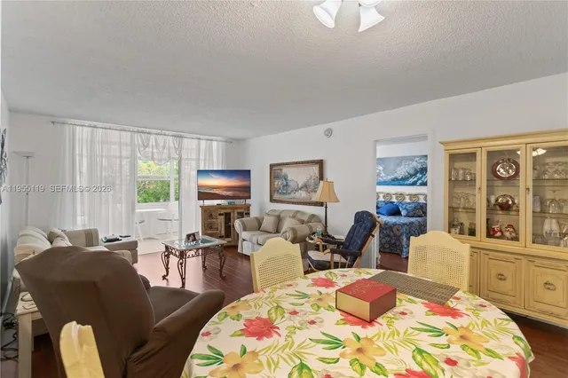 a bedroom with a bed a couch and wooden floor