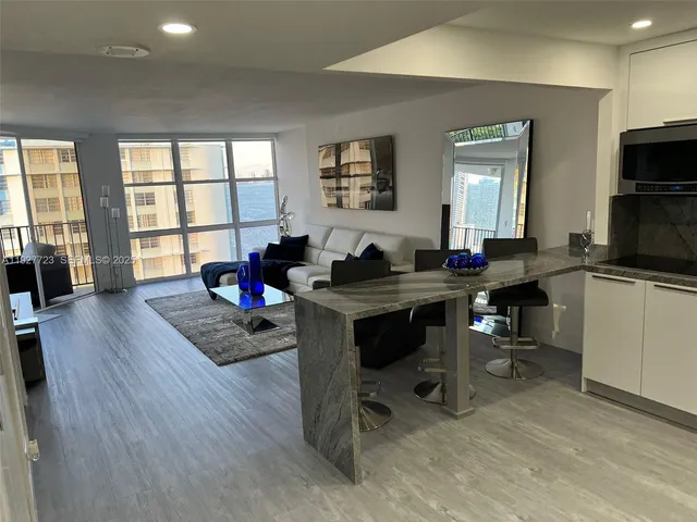 a living room with furniture a flat screen tv and a large window